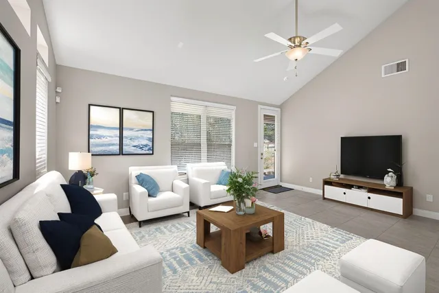 a living room with furniture a flat screen tv and a large window