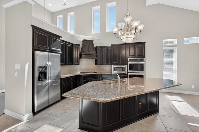 a kitchen with granite countertop wood cabinets and stainless steel appliances