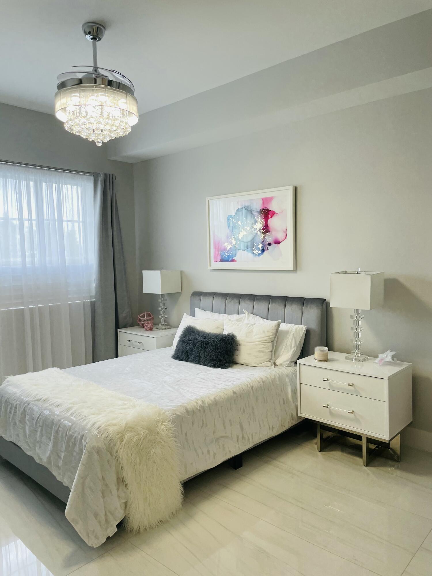 155 East Boca Raton Road, Unit 313 Boca Raton, FL 33432 - Photo 14 of 35 a bedroom with a bed and a chandelier