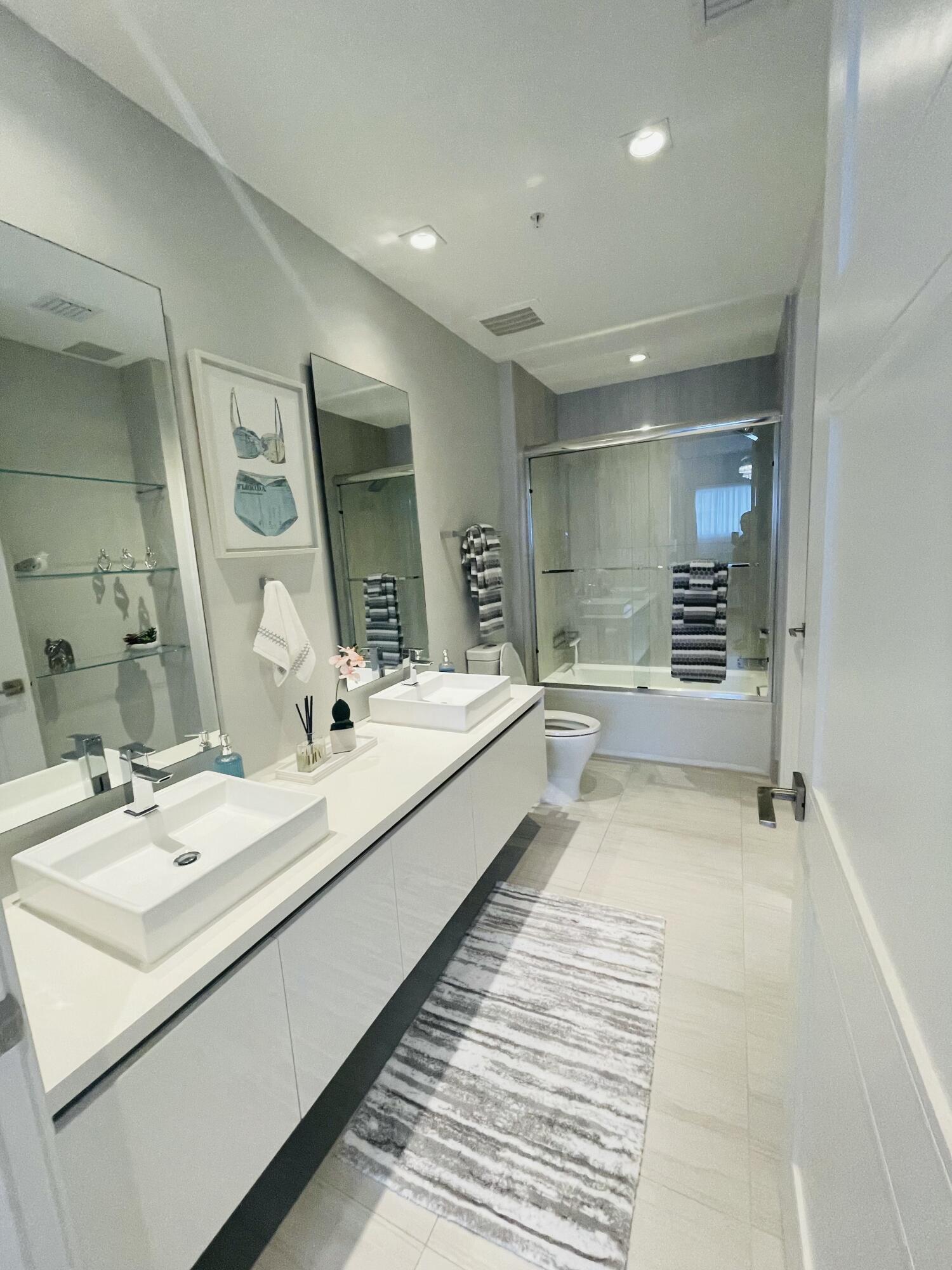 155 East Boca Raton Road, Unit 313 Boca Raton, FL 33432 - Photo 15 of 35 a bathroom with a double vanity sink and mirror