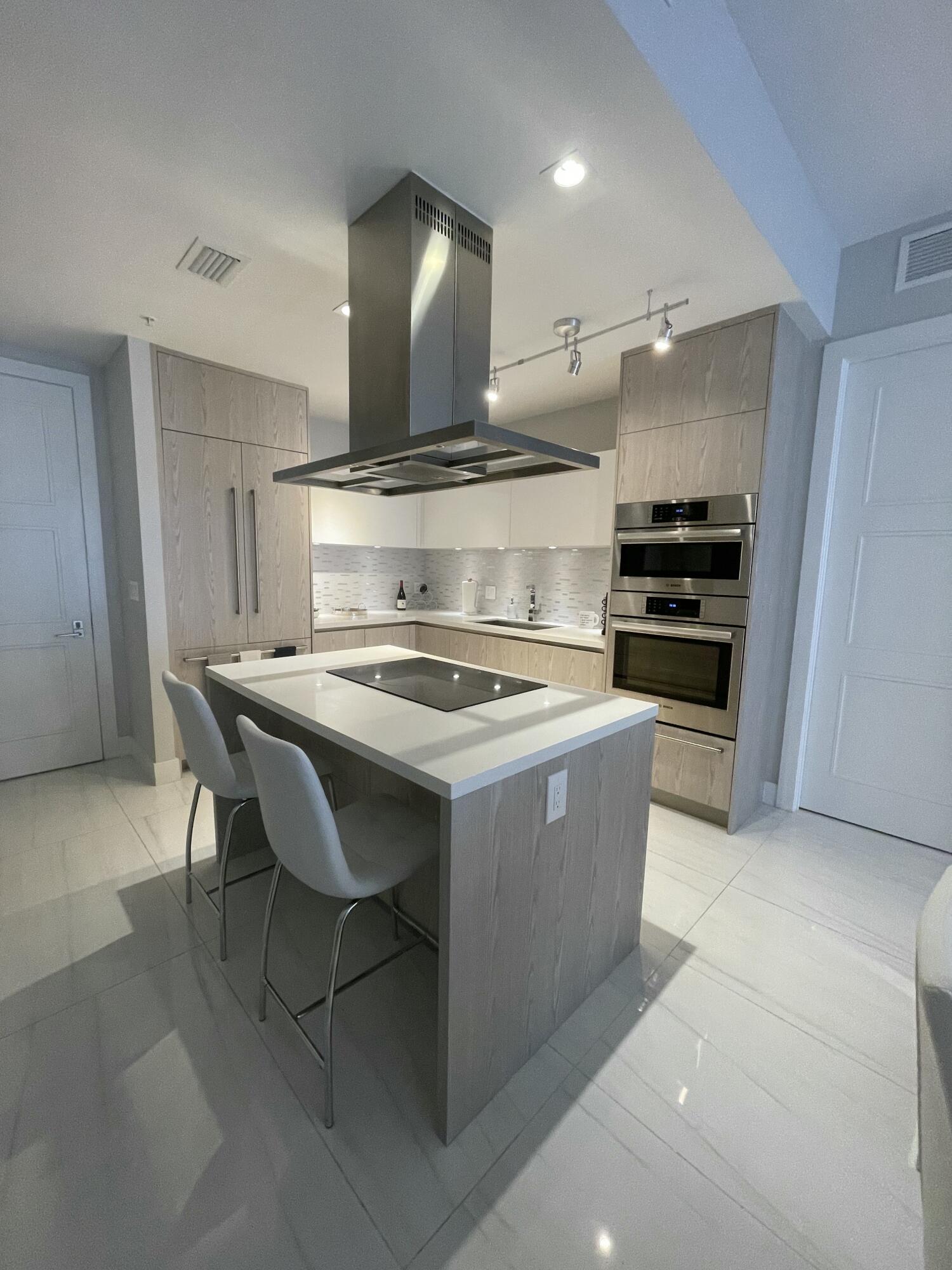 155 East Boca Raton Road, Unit 313 Boca Raton, FL 33432 - Photo 4 of 35 a kitchen with a stove a refrigerator and chairs