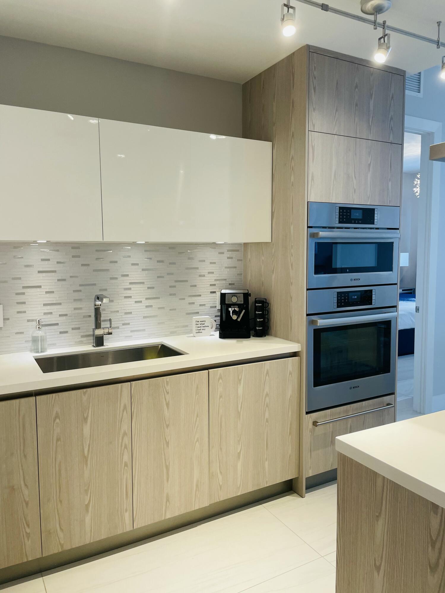 155 East Boca Raton Road, Unit 313 Boca Raton, FL 33432 - Photo 6 of 35 a kitchen with stainless steel appliances a sink dishwasher stove refrigerator and cabinets