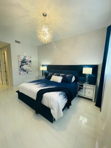 a bedroom with a bed and a chandelier