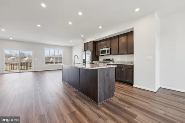 a kitchen with granite countertop wooden cabinets a sink dishwasher stove and refrigerator with granite countertops