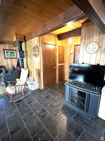 1456 Navajo Road Coalville, UT 84017 - Photo 18 of 55 Sitting room featuring wood walls, a wood stove, and a wooden ceiling with exposed beams