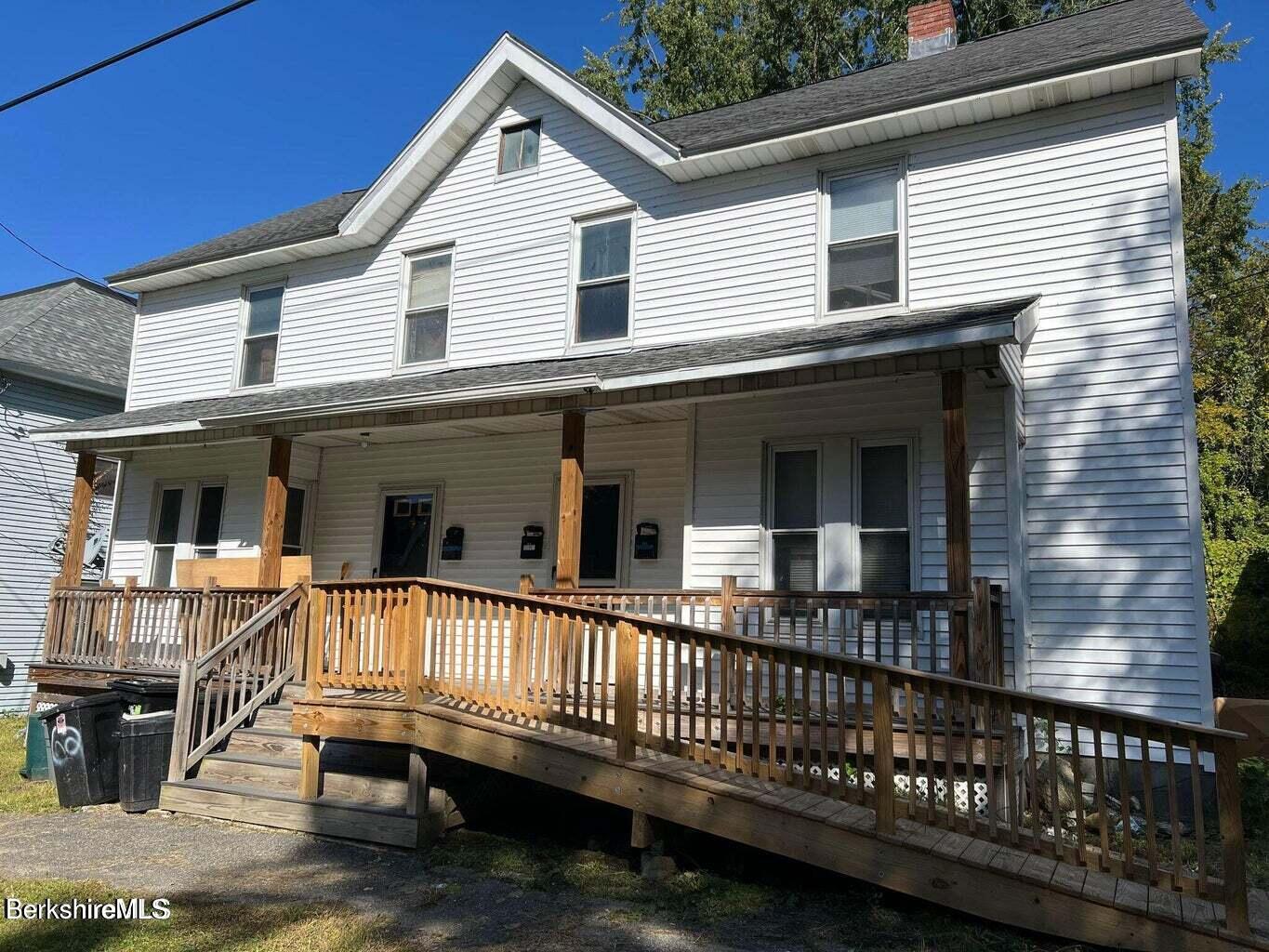 a view of a house with wooden deck and furniture