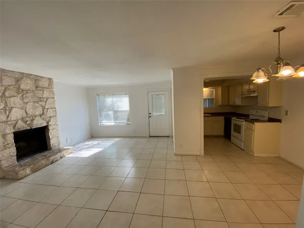 an empty room with windows and fireplace