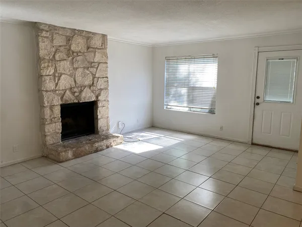 a view of empty room with fireplace and window
