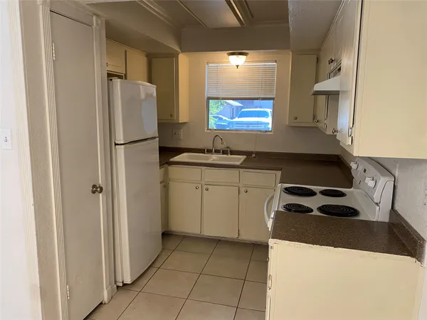 a kitchen with a refrigerator and a stove top oven