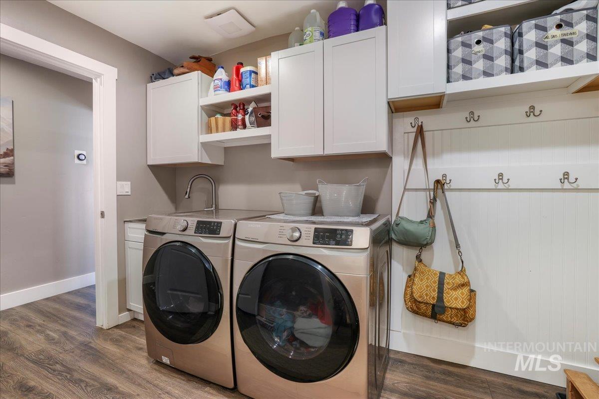 4076 North 3446 East Kimberly, ID 83341 - Photo 25 of 45 Laundry area featuring washer and clothes dryer, cabinet space, and wood finished floors