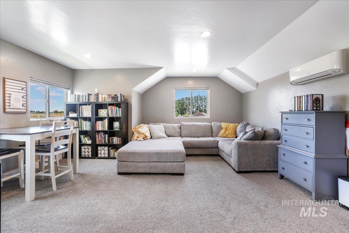 4076 North 3446 East Kimberly, ID 83341 - Photo 28 of 45 Living area featuring a wall unit AC, carpet, vaulted ceiling, and recessed lighting
