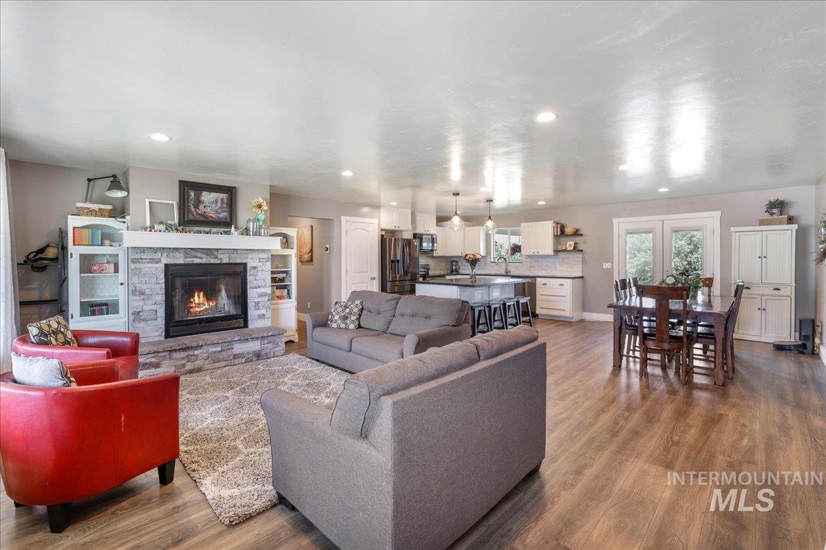 4076 North 3446 East Kimberly, ID 83341 - Photo 7 of 45 Living room with wood finished floors, a stone fireplace, and recessed lighting
