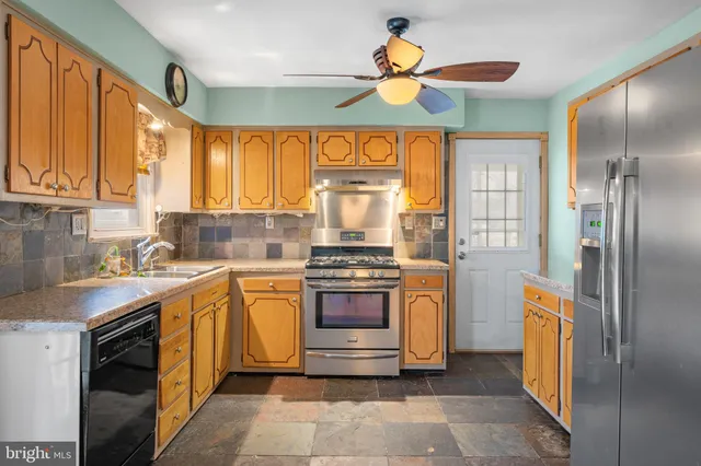a large kitchen with stainless steel appliances granite countertop a stove and a sink
