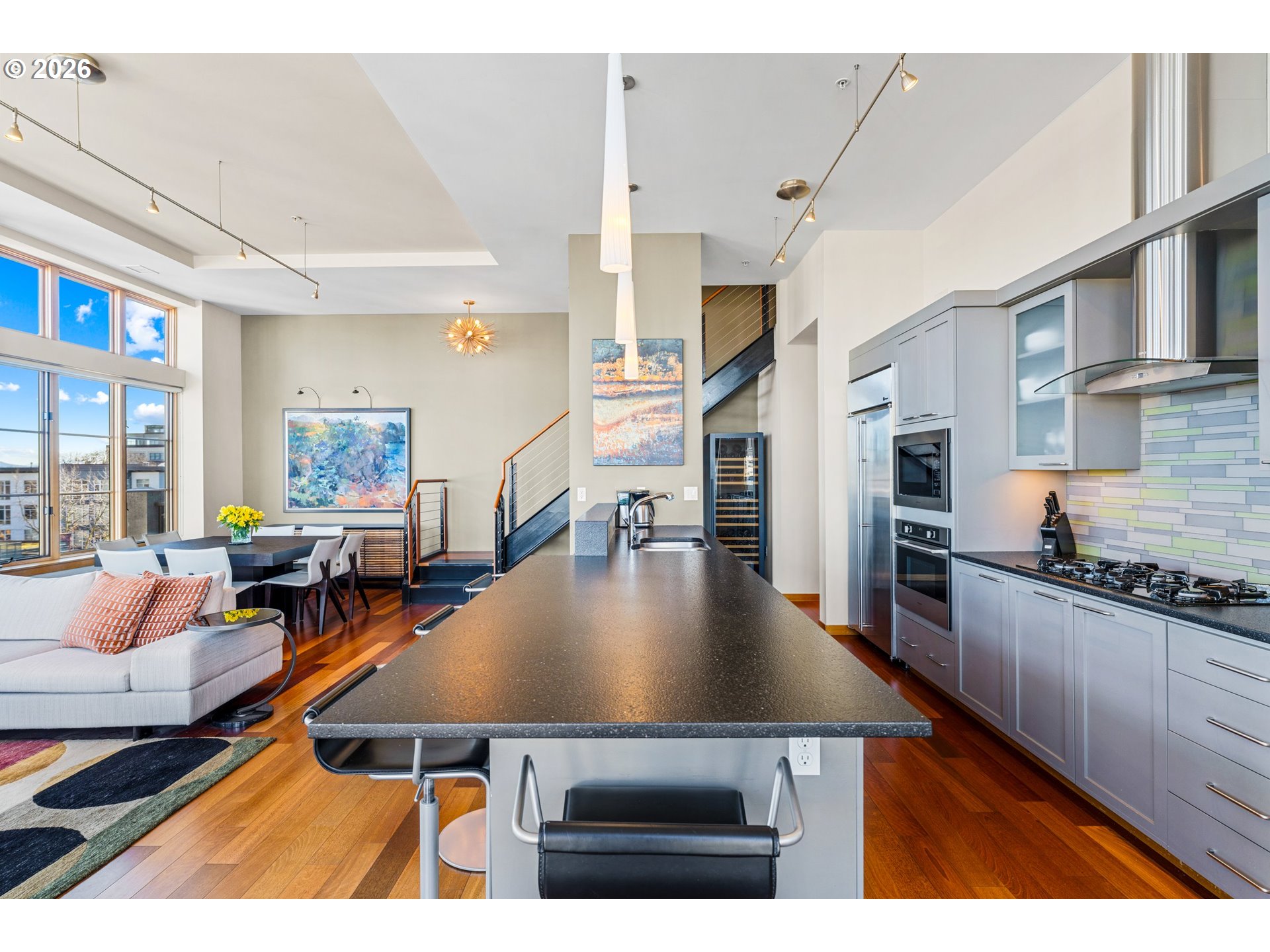 1030 Northwest Johnson Street, Unit 611 Portland, OR 97209 - Photo 12 of 34 a living room with stainless steel appliances kitchen island granite countertop a stove a kitchen island a dining table and chairs with the wooden floor