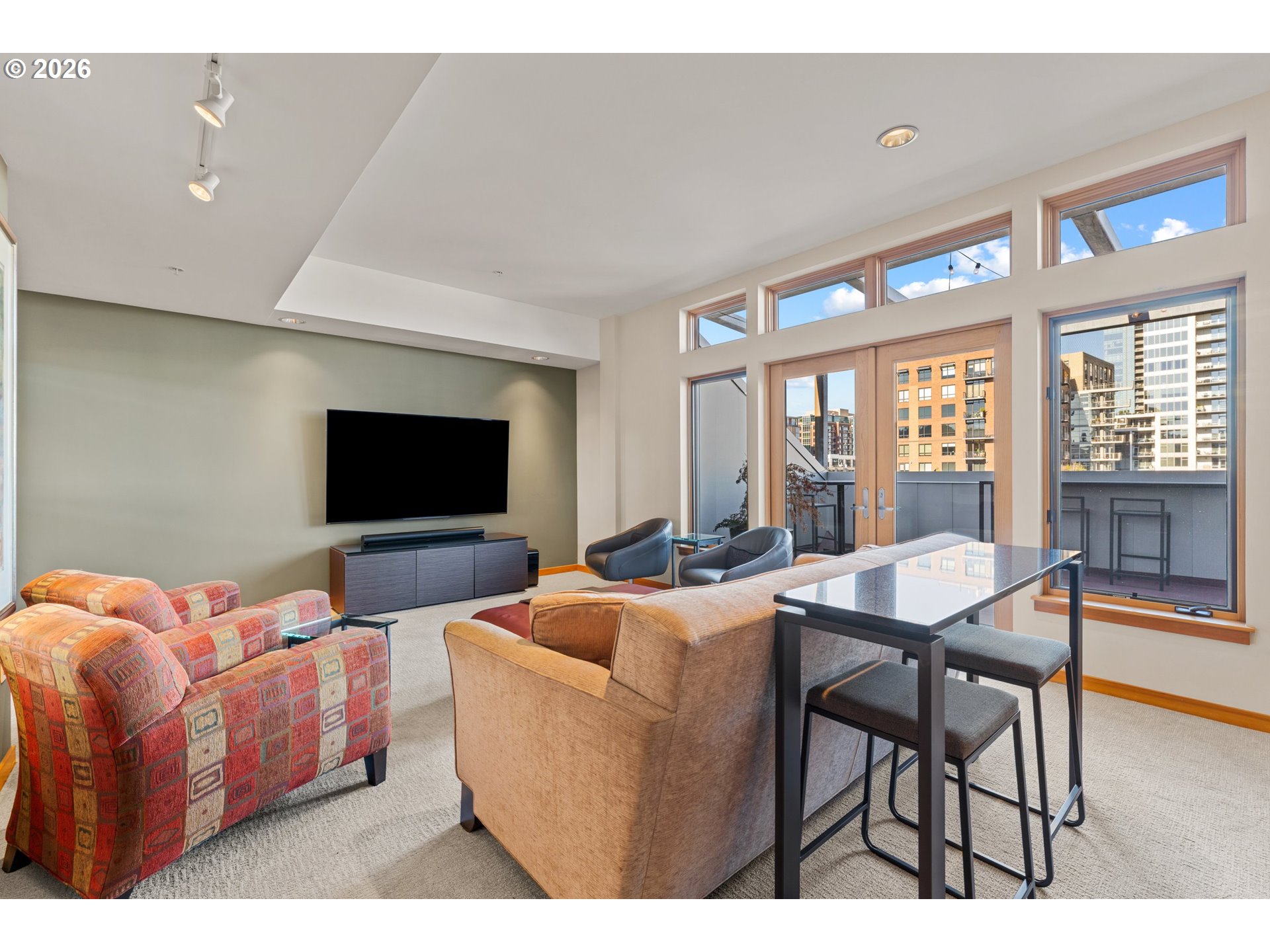 1030 Northwest Johnson Street, Unit 611 Portland, OR 97209 - Photo 29 of 34 a living room with furniture a flat screen tv and floor to ceiling window