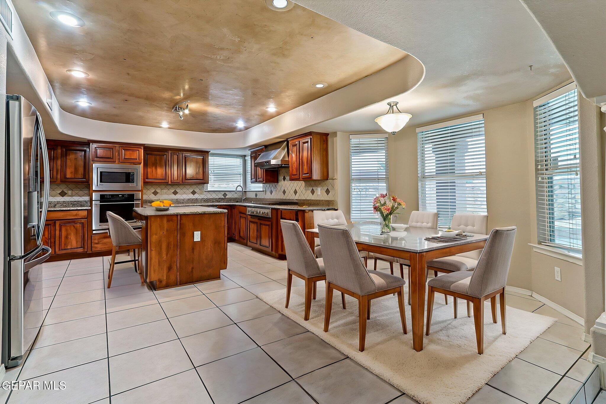 3644 Tierra Inca Drive El Paso, TX 79938 - Photo 15 of 53 a kitchen with stainless steel appliances granite countertop a stove a sink dishwasher and a refrigerator with wooden cabinets