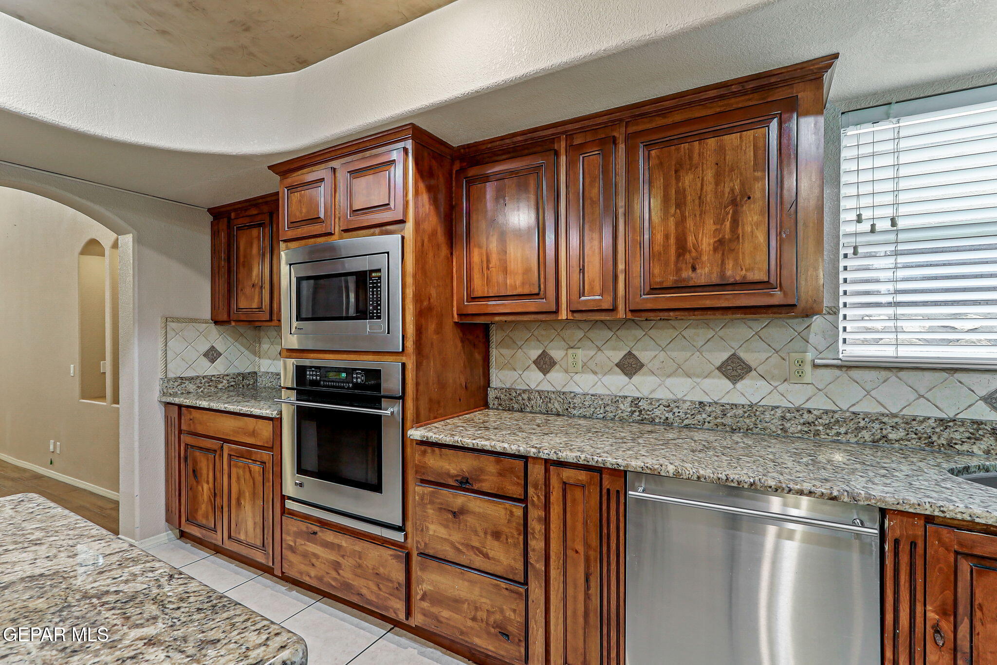 3644 Tierra Inca Drive El Paso, TX 79938 - Photo 10 of 53 a kitchen with stainless steel appliances granite countertop a stove microwave and refrigerator