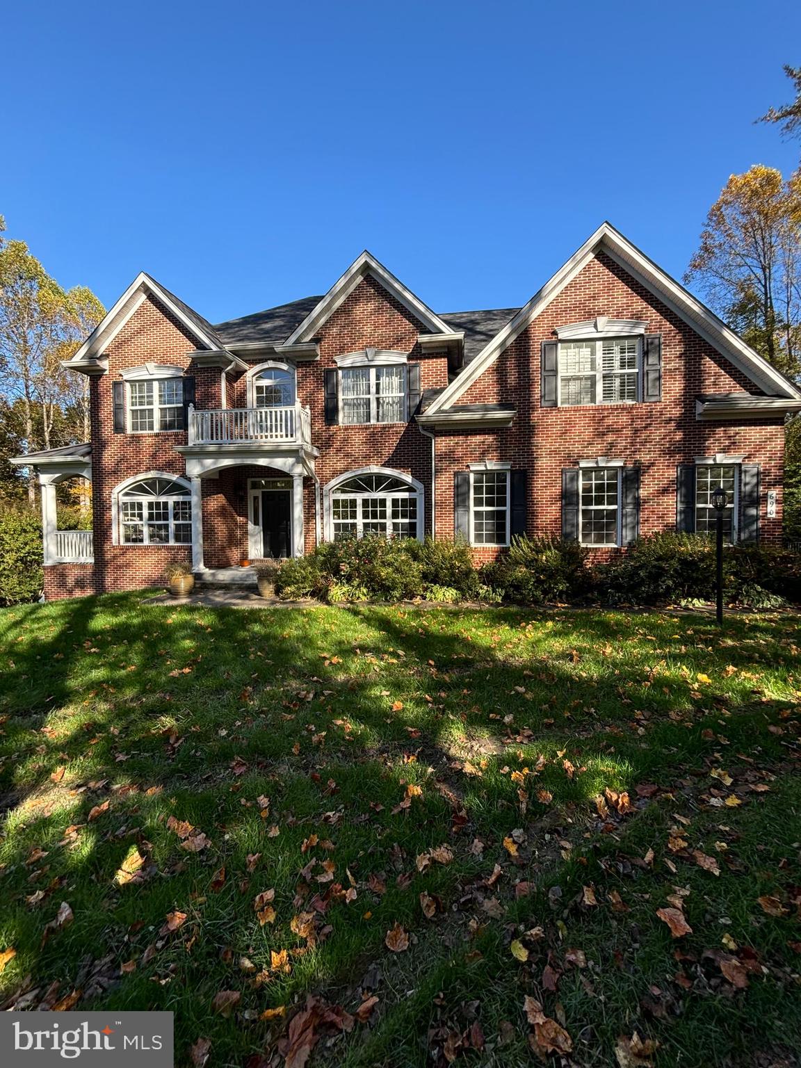 a front view of a residential houses with yard and green space
