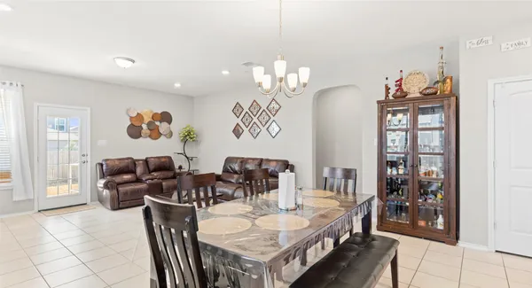 a living room with furniture a chandelier and a dining table