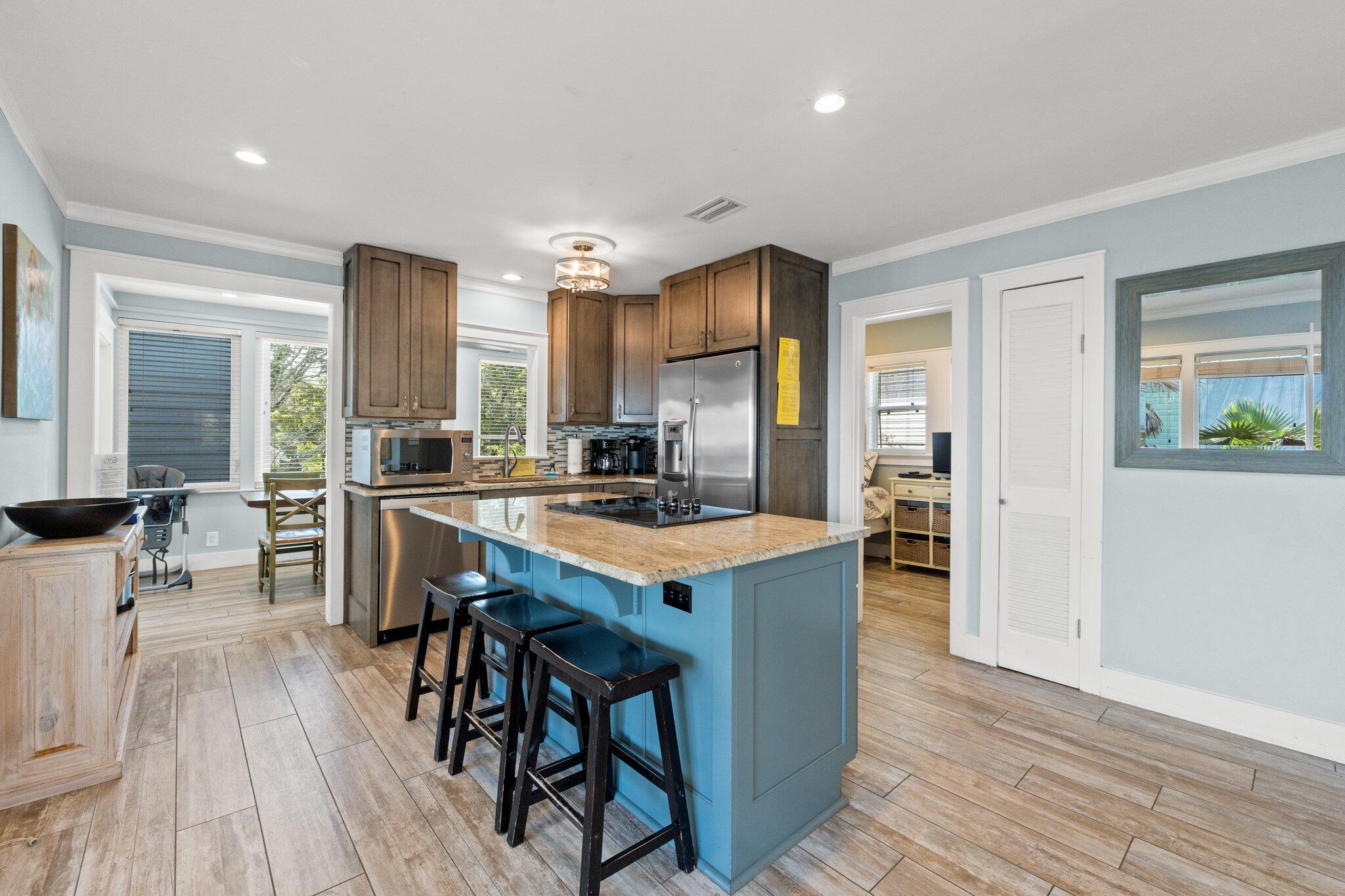 91 Cypress Hill Road Santa Rosa Beach, FL 32459 - Photo 31 of 66 a kitchen with stainless steel appliances granite countertop a stove top oven a refrigerator a dining table and chairs with wooden floor