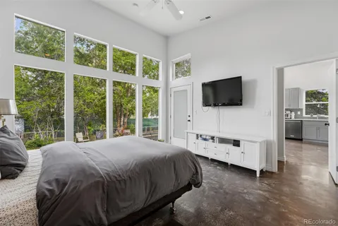 a bedroom with a bed and a flat tv screen on the dresser