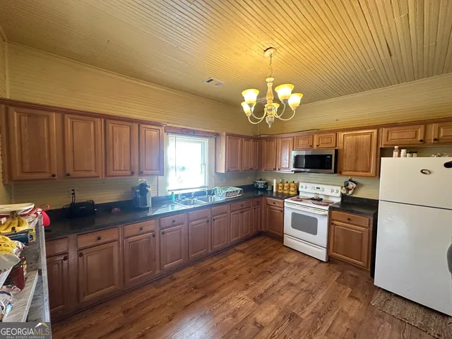 a kitchen with kitchen island granite countertop stainless steel appliances stove microwave refrigerator and cabinets