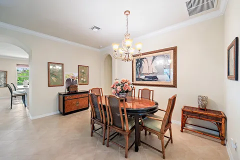a dining hall with couches a flat tv screen and a dining table with garden view