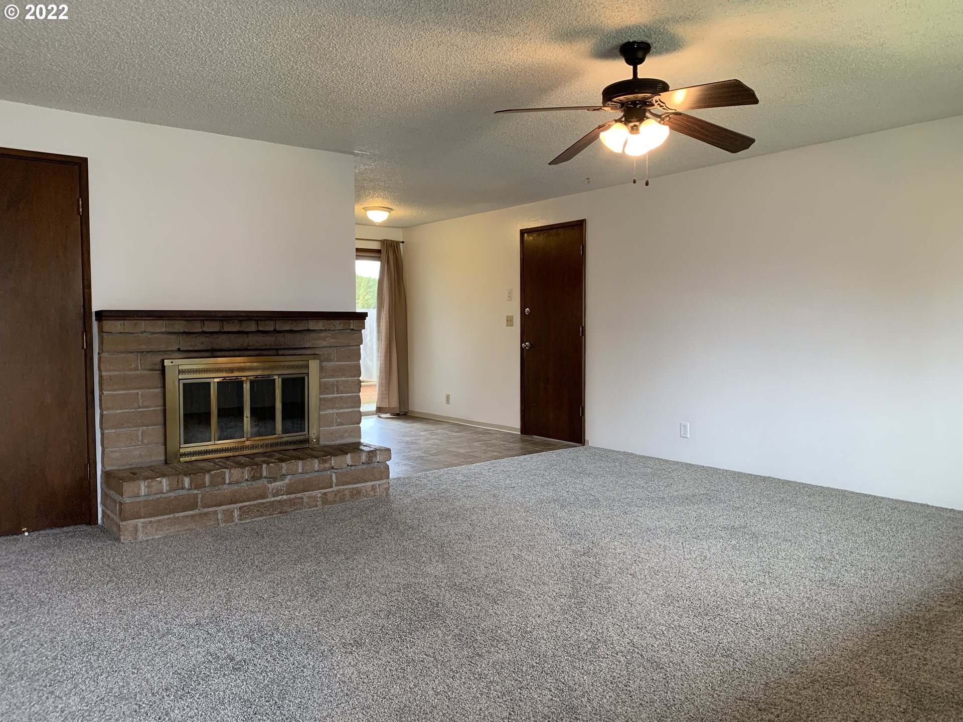 296 South 50th Place Springfield, OR 97478 - Photo 5 of 32 a view of an empty room with a fireplace and a fan