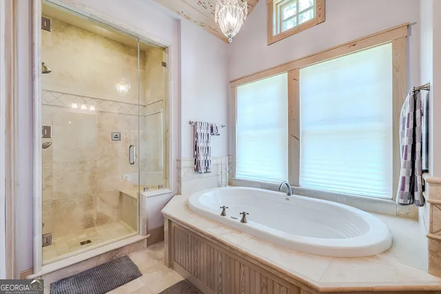 an aerial view of a house with swimming pool and large trees