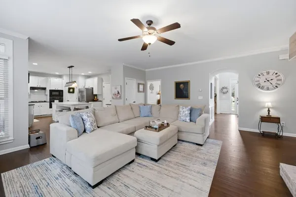a large kitchen with kitchen island a dining table chairs and white cabinets