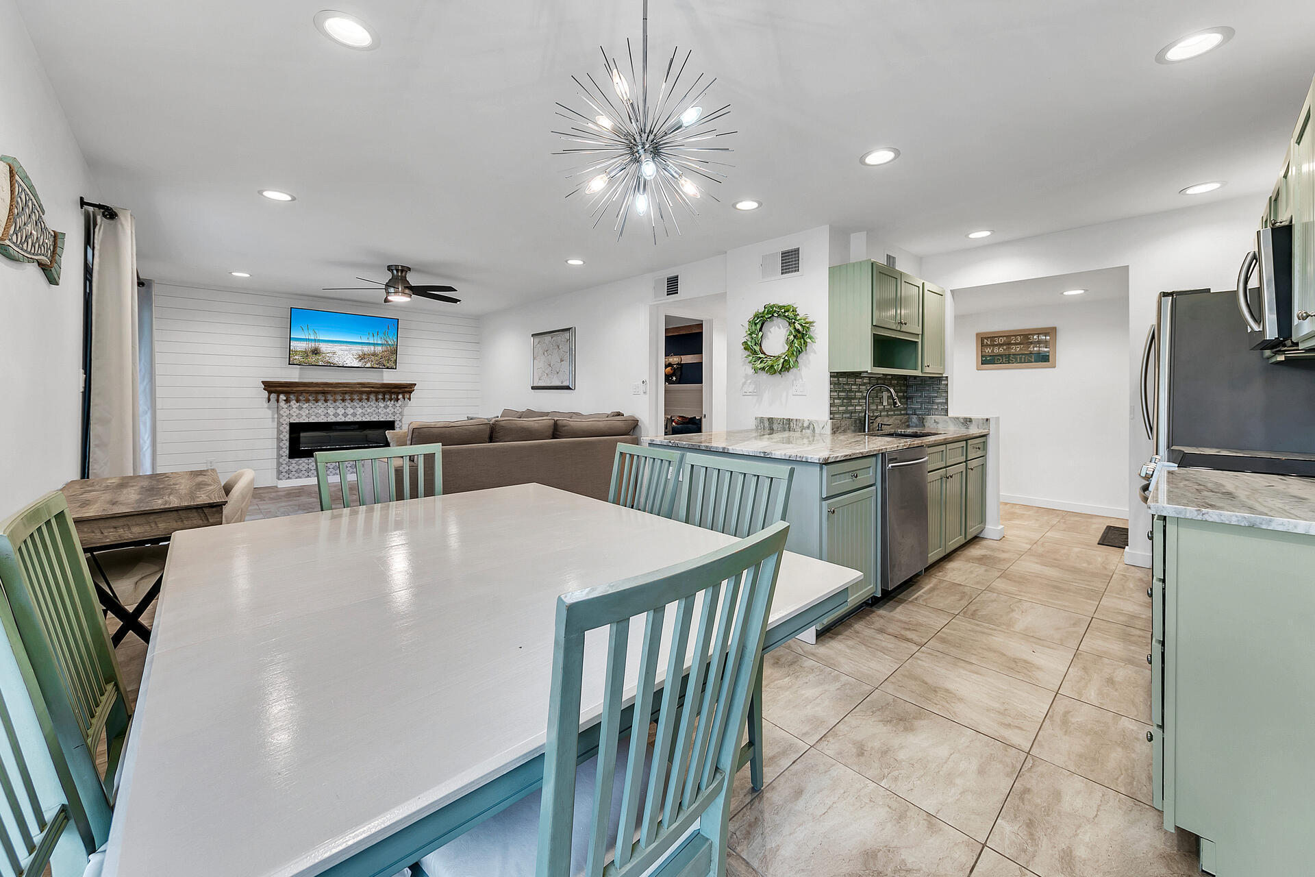 277 Sunset Bay, Unit 27A Miramar Beach, FL 32550 - Photo 12 of 42 a large kitchen with kitchen island a stove a sink a refrigerator and a dining table with wooden floor