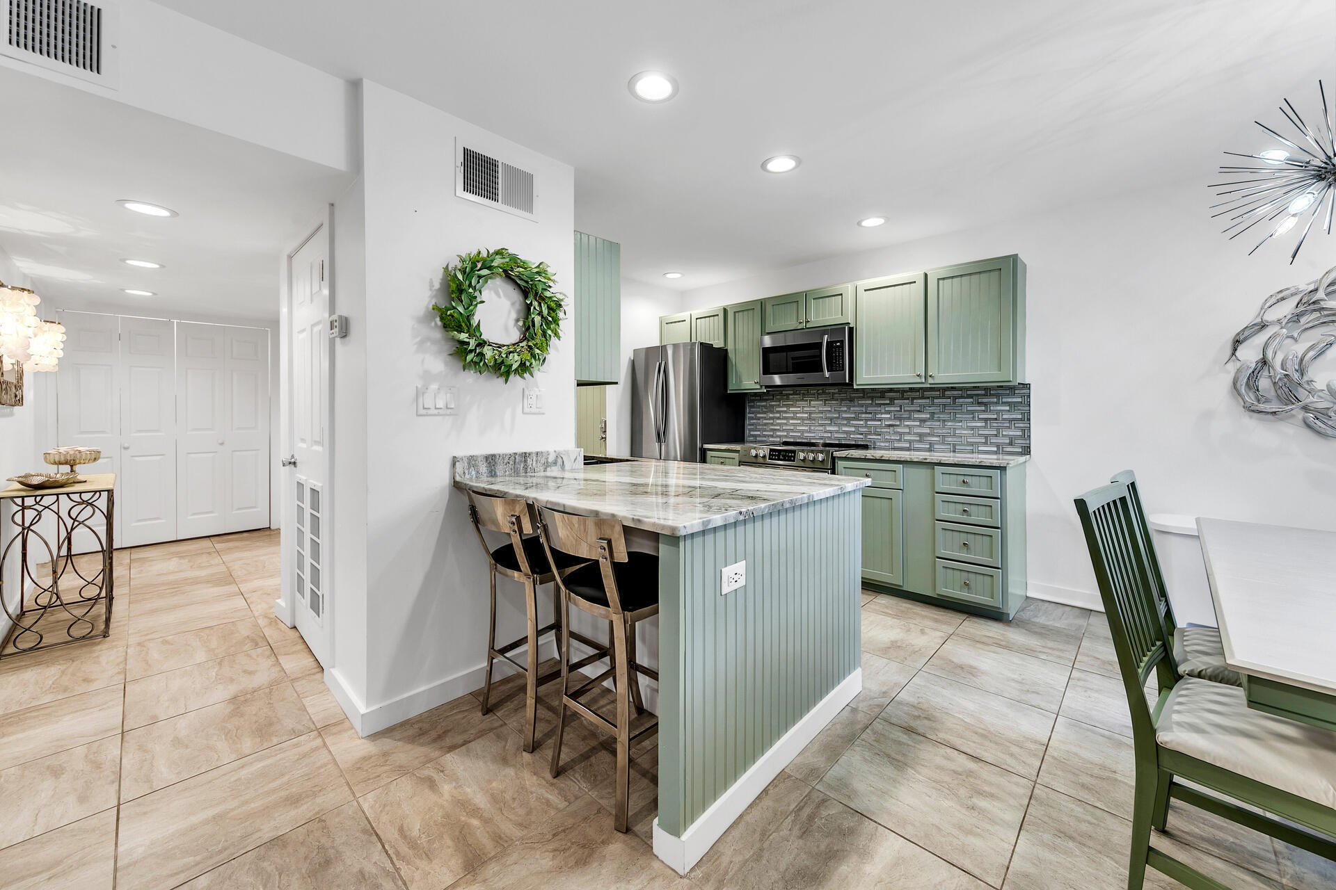 277 Sunset Bay, Unit 27A Miramar Beach, FL 32550 - Photo 13 of 42 a kitchen with kitchen island a sink counter and chairs