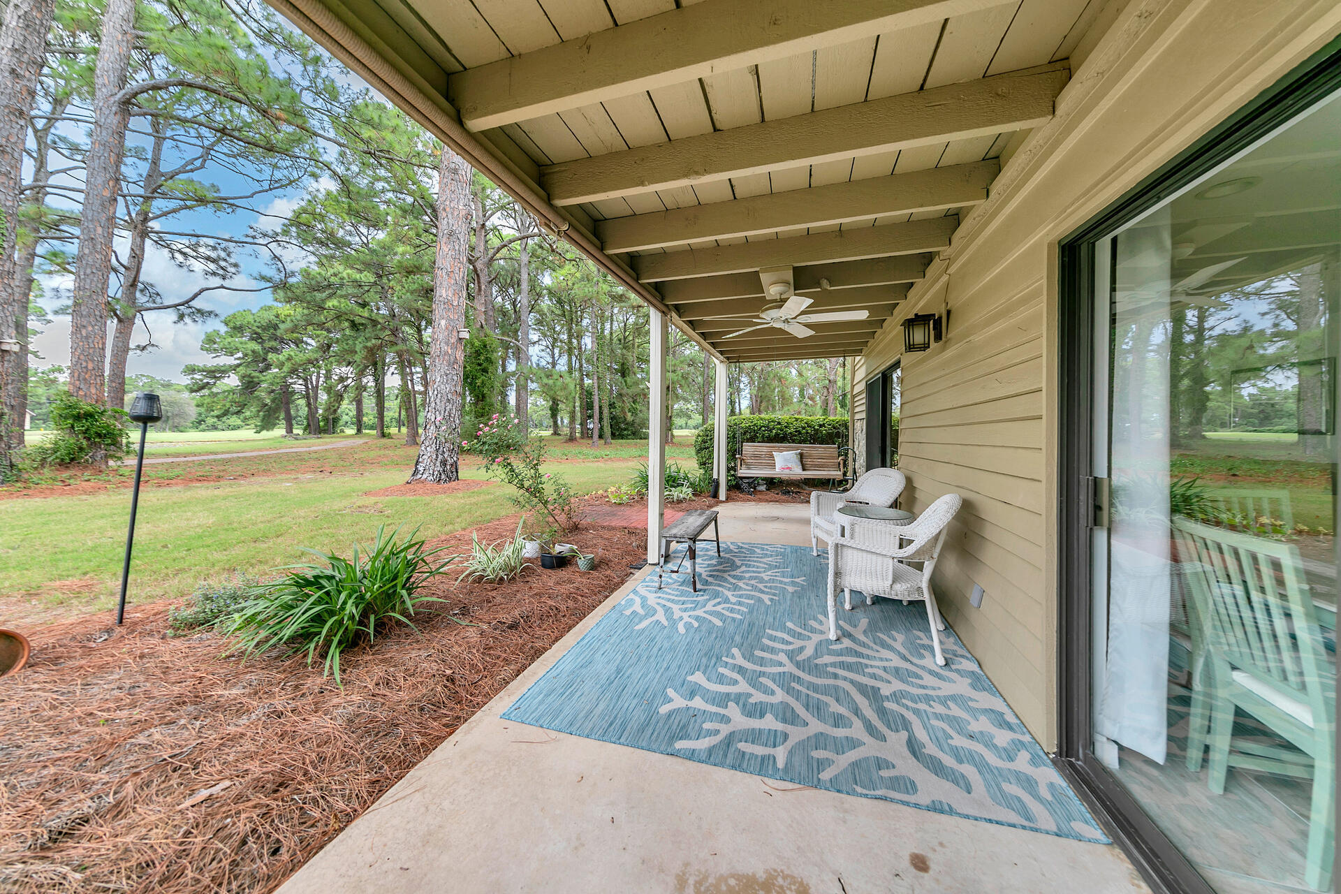 277 Sunset Bay, Unit 27A Miramar Beach, FL 32550 - Photo 34 of 42 a view of a patio with table and chairs potted plants with wooden floor and fence