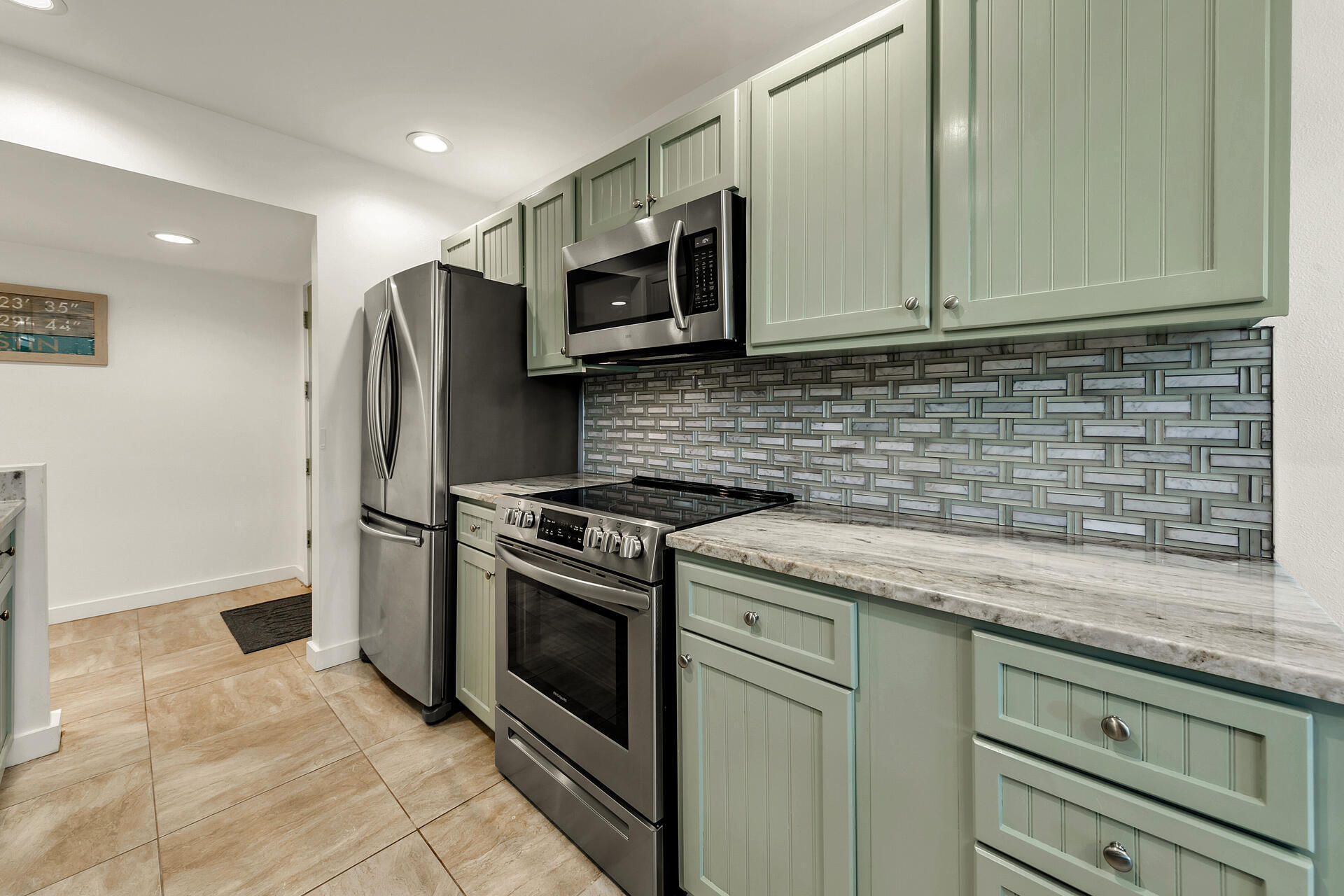 277 Sunset Bay, Unit 27A Miramar Beach, FL 32550 - Photo 9 of 42 a kitchen with stainless steel appliances granite countertop a sink a stove a microwave and a refrigerator