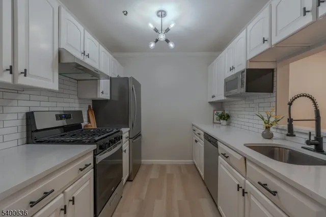 a kitchen with stainless steel appliances a sink stove and refrigerator