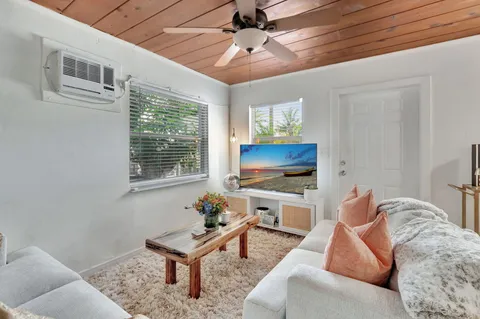 a living room with furniture a flat screen tv and a window