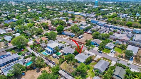 an aerial view of residential houses with outdoor space and trees all around
