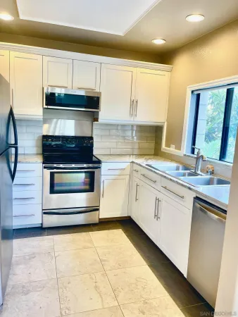 a kitchen with stainless steel appliances granite countertop a stove a sink and a microwave