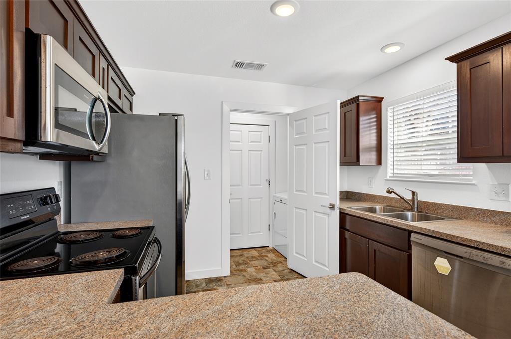 704 East Sycamore Street Sherman, TX 75090 - Photo 12 of 32 a kitchen with a sink stove and cabinets