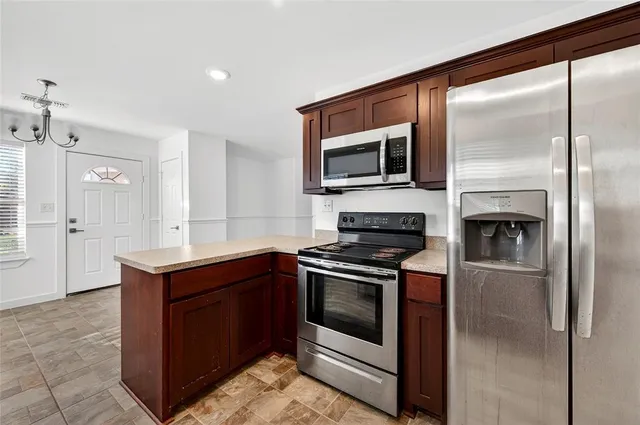 a kitchen with stainless steel appliances granite countertop a stove a microwave and a refrigerator