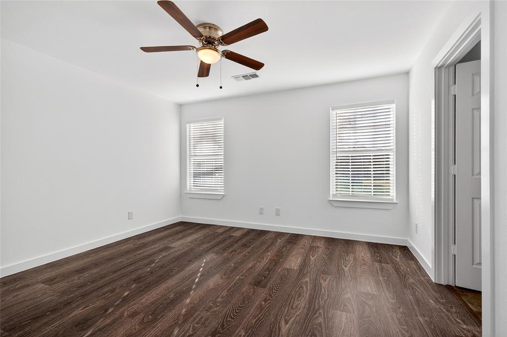 704 East Sycamore Street Sherman, TX 75090 - Photo 18 of 32 an empty room with wooden floor ceiling fan and windows