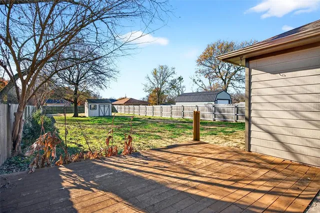 a view of a house with backyard and a tree