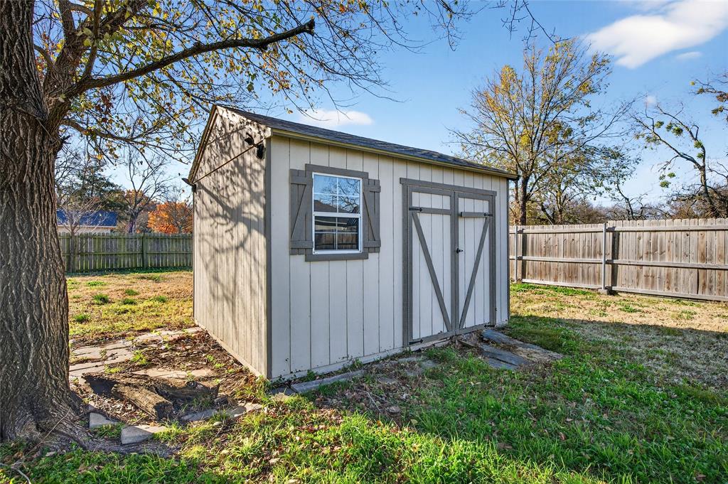 704 East Sycamore Street Sherman, TX 75090 - Photo 30 of 32 a view of a backyard with wooden fence and large trees