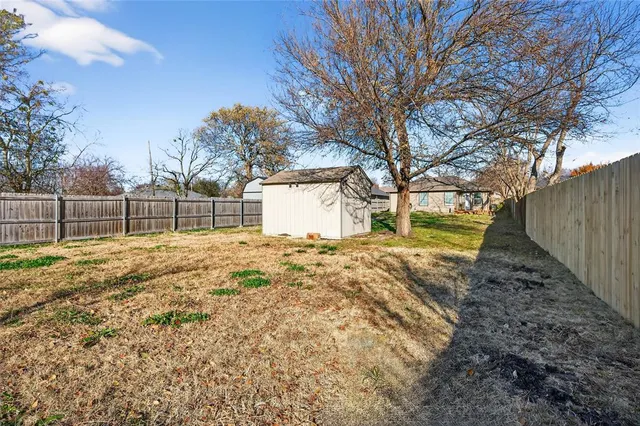 a view of a yard with wooden fence