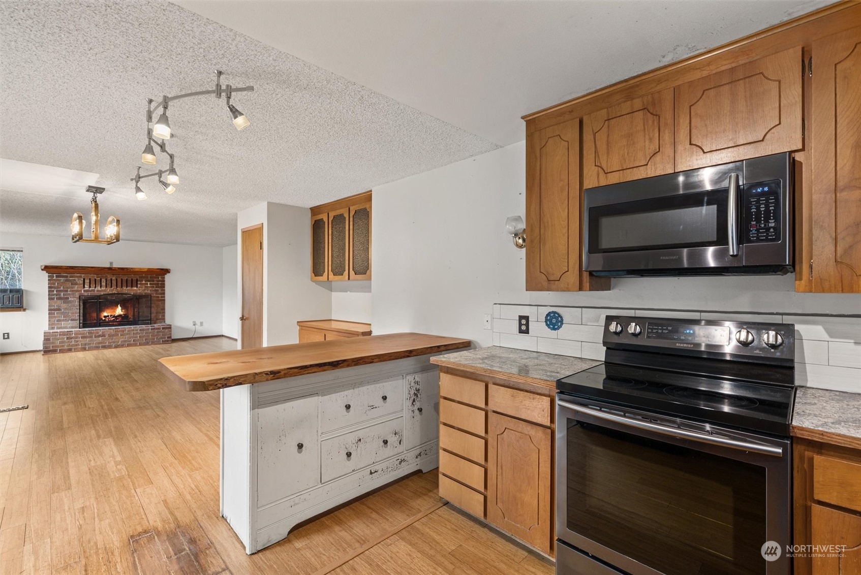 32717 Sultan Basin Road Sultan, WA 98294 - Photo 12 of 31 a kitchen with granite countertop a stove microwave and oven