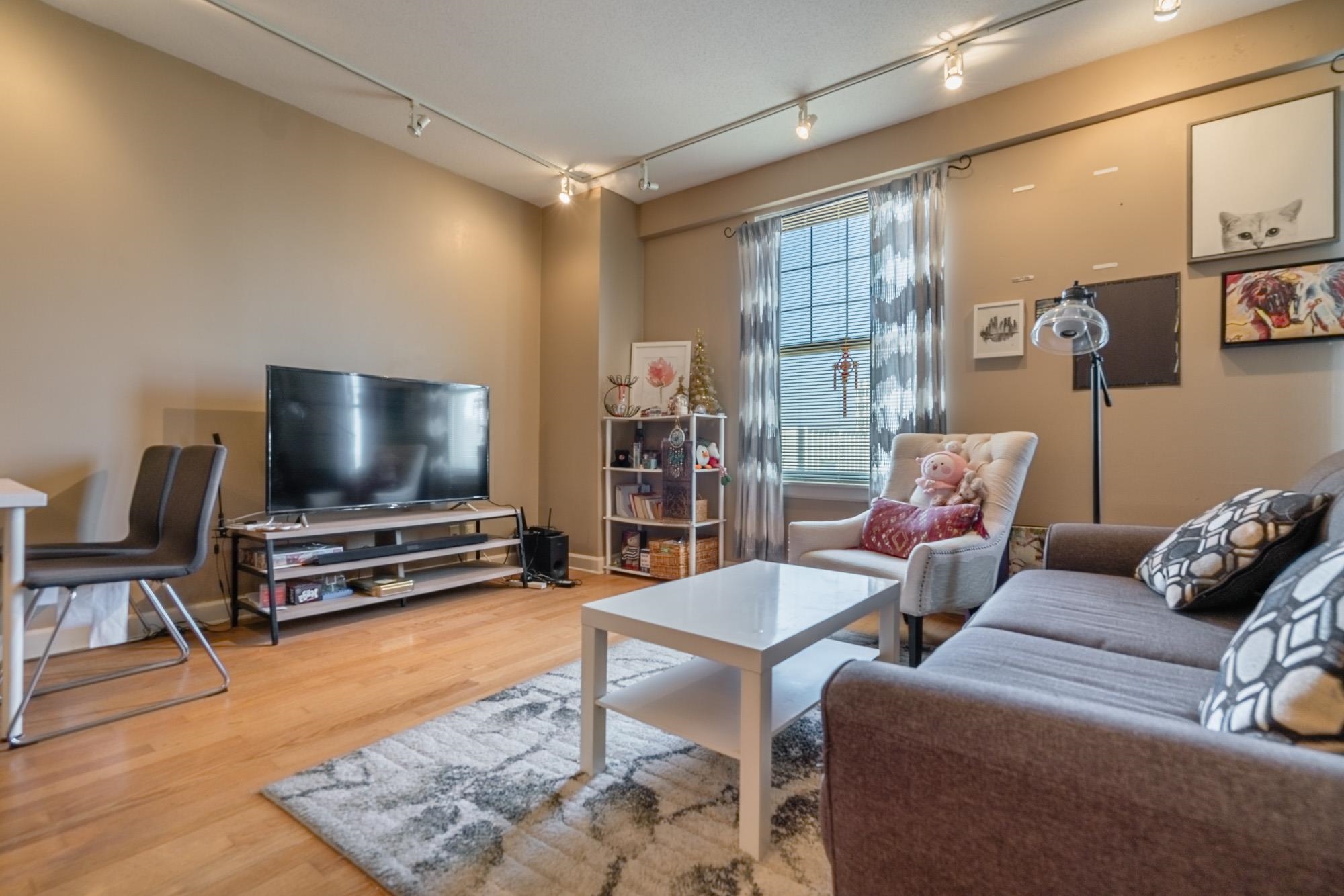 109 North Main Street, Unit 908 Memphis, TN 38103 - Photo 11 of 22 a living room with furniture and a flat screen tv