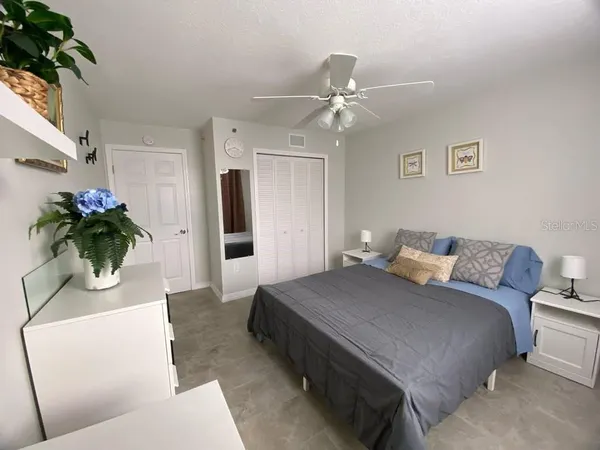 a living room with a bed furniture and a potted plant
