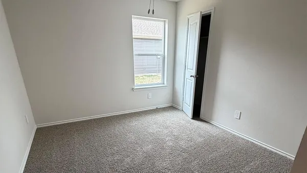 an empty room with windows and closet