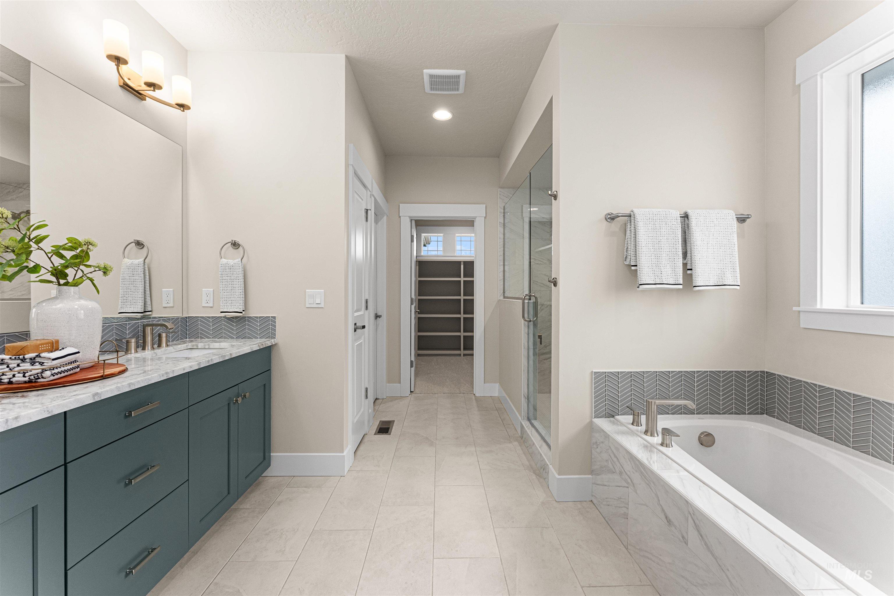 8078 Tandy Cv Street Middleton, ID 83644 - Photo 22 of 40 Full bathroom with vanity, a stall shower, a spacious closet, and a garden tub