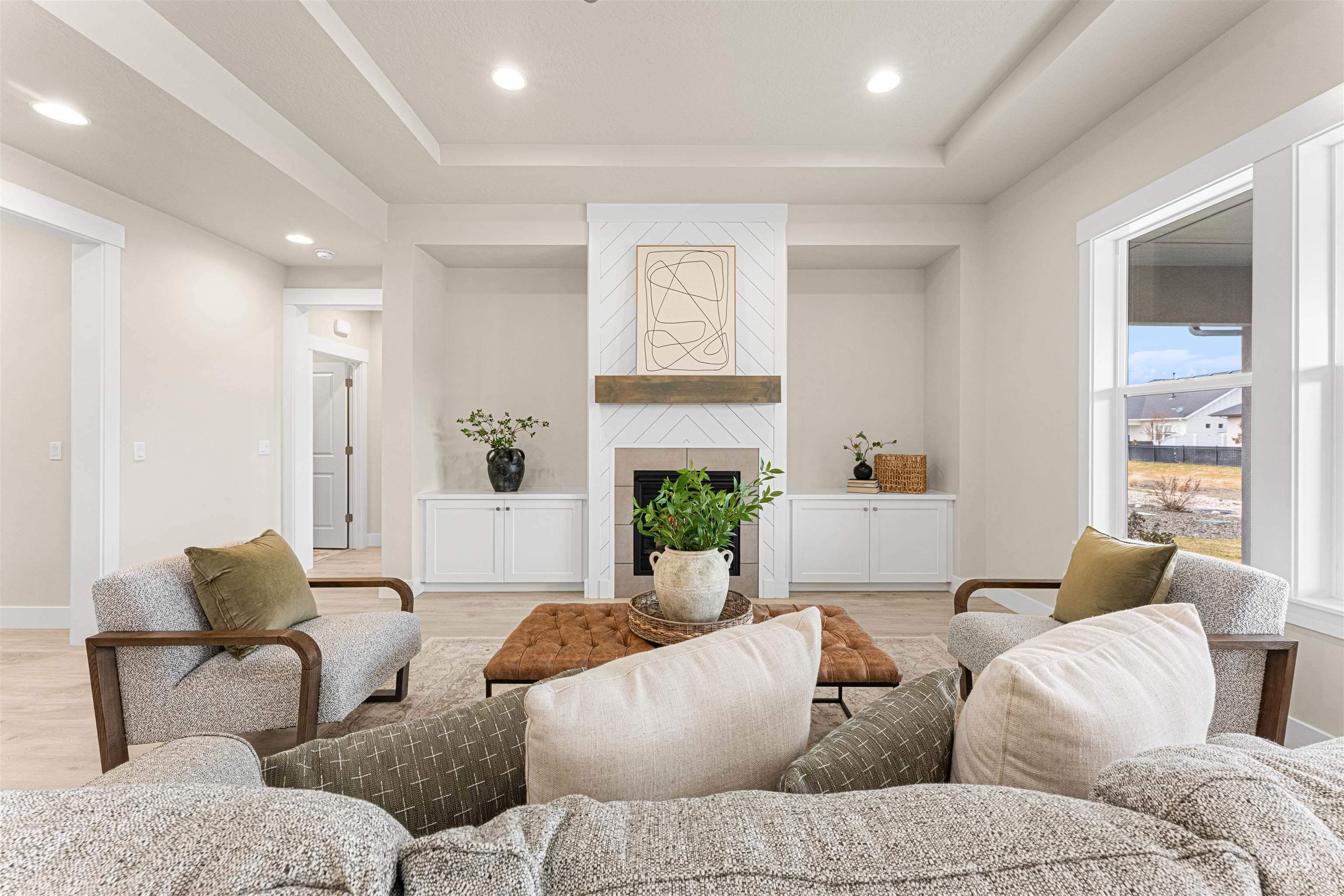 8078 Tandy Cv Street Middleton, ID 83644 - Photo 3 of 40 Living room featuring light wood-style floors, a tray ceiling, recessed lighting, and a large fireplace